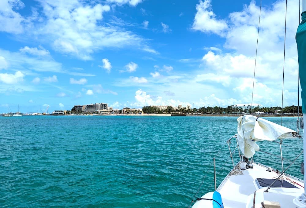 Turquoise water, and town of Nassau, Bahamas seen from deck of a sailboat entering the channel.